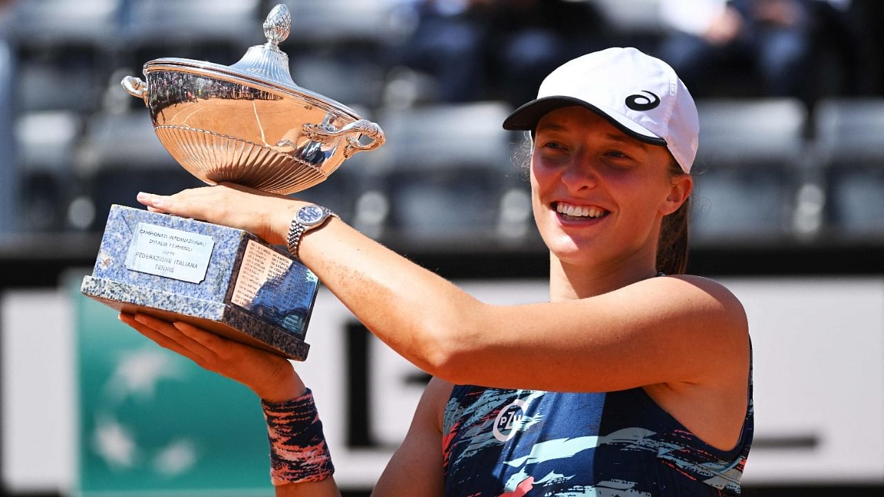 Poland's Iga Swiatek holds the winner's trophy after defeating Tunisia's Ons Jabeur to win the final of the Women's WTA Rome Open tennis tournament. Credit: AFP Photo