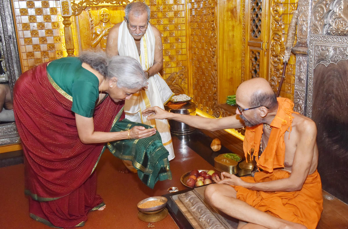 Union Finance Minister Nirmala Sitharaman receives prasadam from Paryaya Krishnapura Mutt seer Vidyasagara Theertha Swami in Udupi. 
