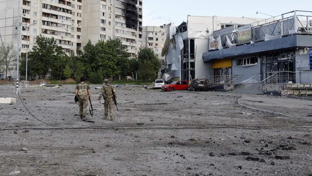 Ukrainian servicemen walk at a damaged area, as Russia's attack on Ukraine continues, in Kharkiv. Credit: Reuters photo