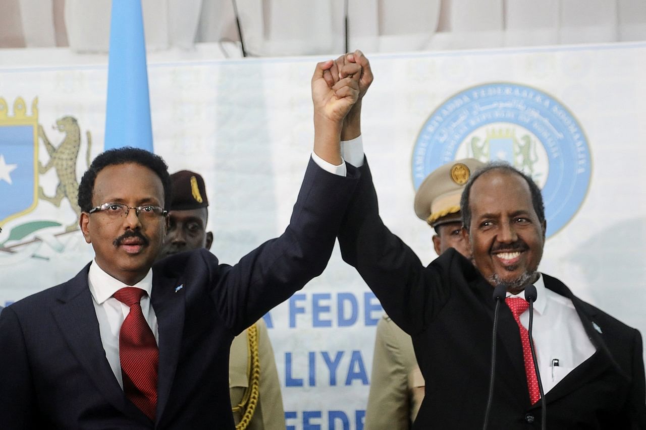 Somalia's newly elected president Hassan Sheikh Mohamud holds hands with incumbent president Mohamed Abdullahi Mohamed. Credit: Reuters Photo
