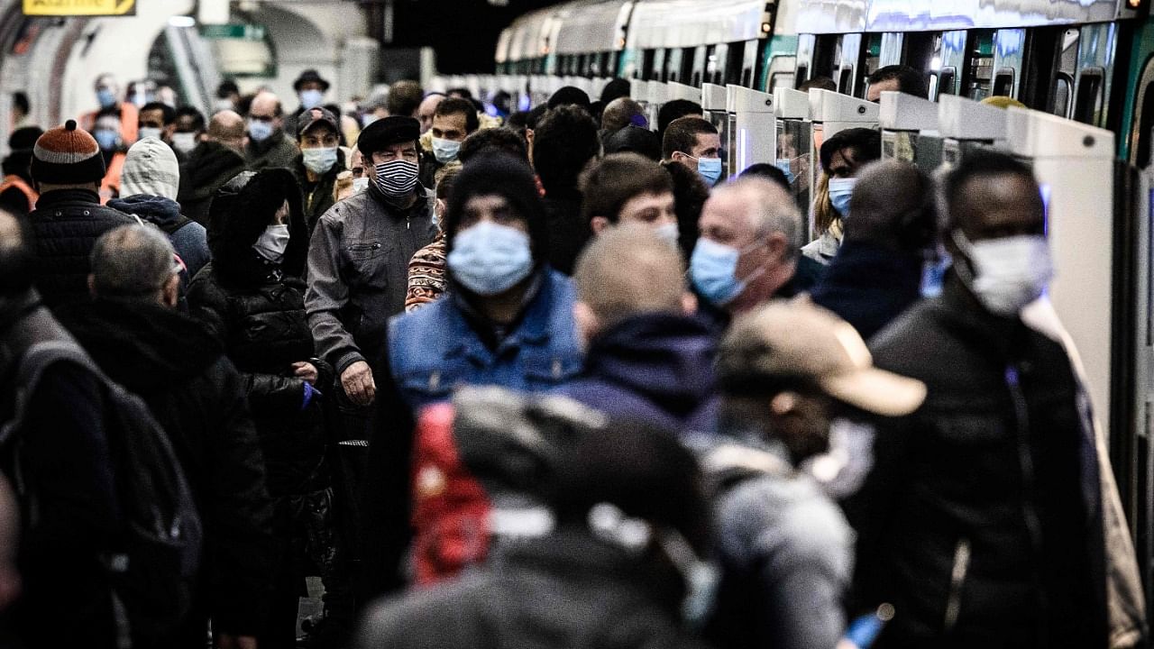 n this file photo taken of commuters wearing facemasks walk at the Saint-Lazare platform of line 13 metro station in Paris. Credit: AFP Photo
