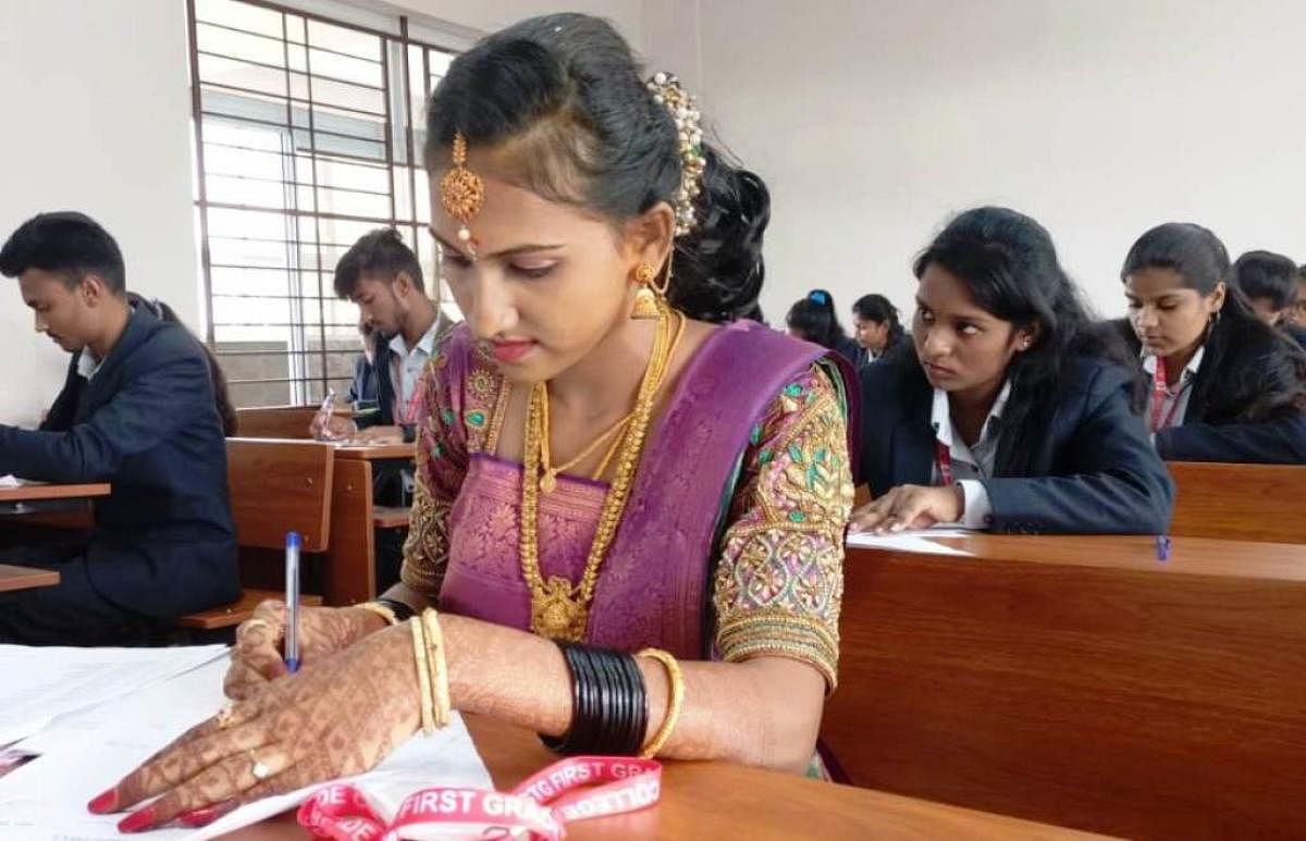 Bride Aishwarya appears for the exam immediately after her marriage at the STG Educational Institution in Chinakurali village of Pandavapura taluk, recently.