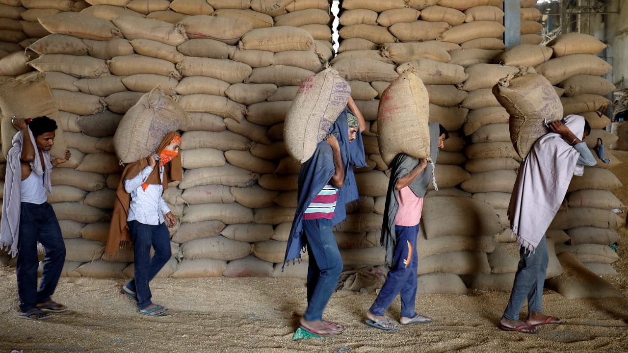 Workers carry sacks of wheat for sifting at a grain mill on the outskirts of Ahmedabad. Credit: Reuters File Photo