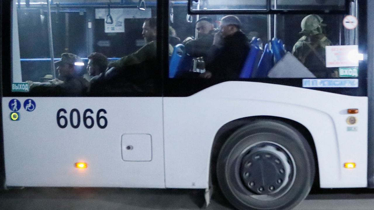 A bus carrying service members of Ukrainian forces from the besieged Azovstal steel mill drives away under escort of the pro-Russian military in the course of Ukraine-Russia conflict. Credit: Reuters Photo