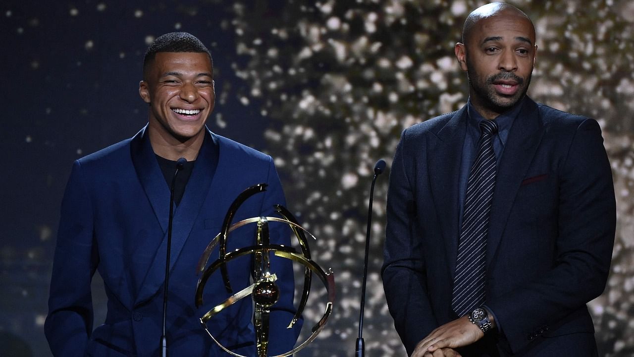 Paris Saint-Germain's French forward Kylian Mbappe (L) receives the Best Ligue 1 Player award from former player Thierry Henry. Credit: AFP Photo