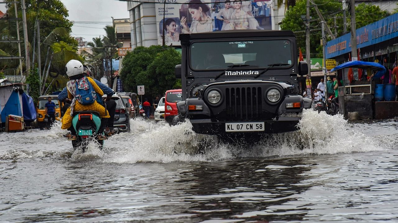 Vehicles wade through a waterlogged road after heavy rain in Kochi. Credit: PTI File Photo
