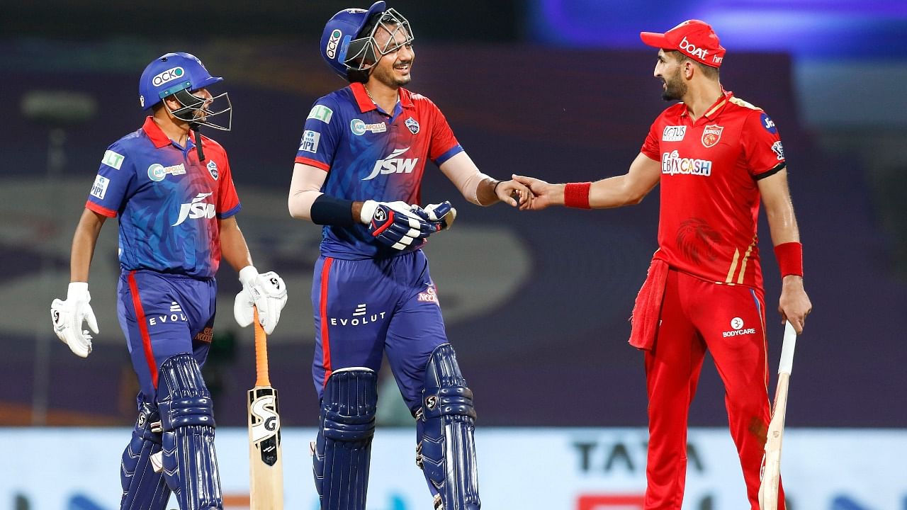 Axar Patel of Delhi Capitals and Rishi Dhawan of Punjab Kings greet each other during the 64th T20 cricket match of the Indian Premier League 2022. Credit: PTI Photo