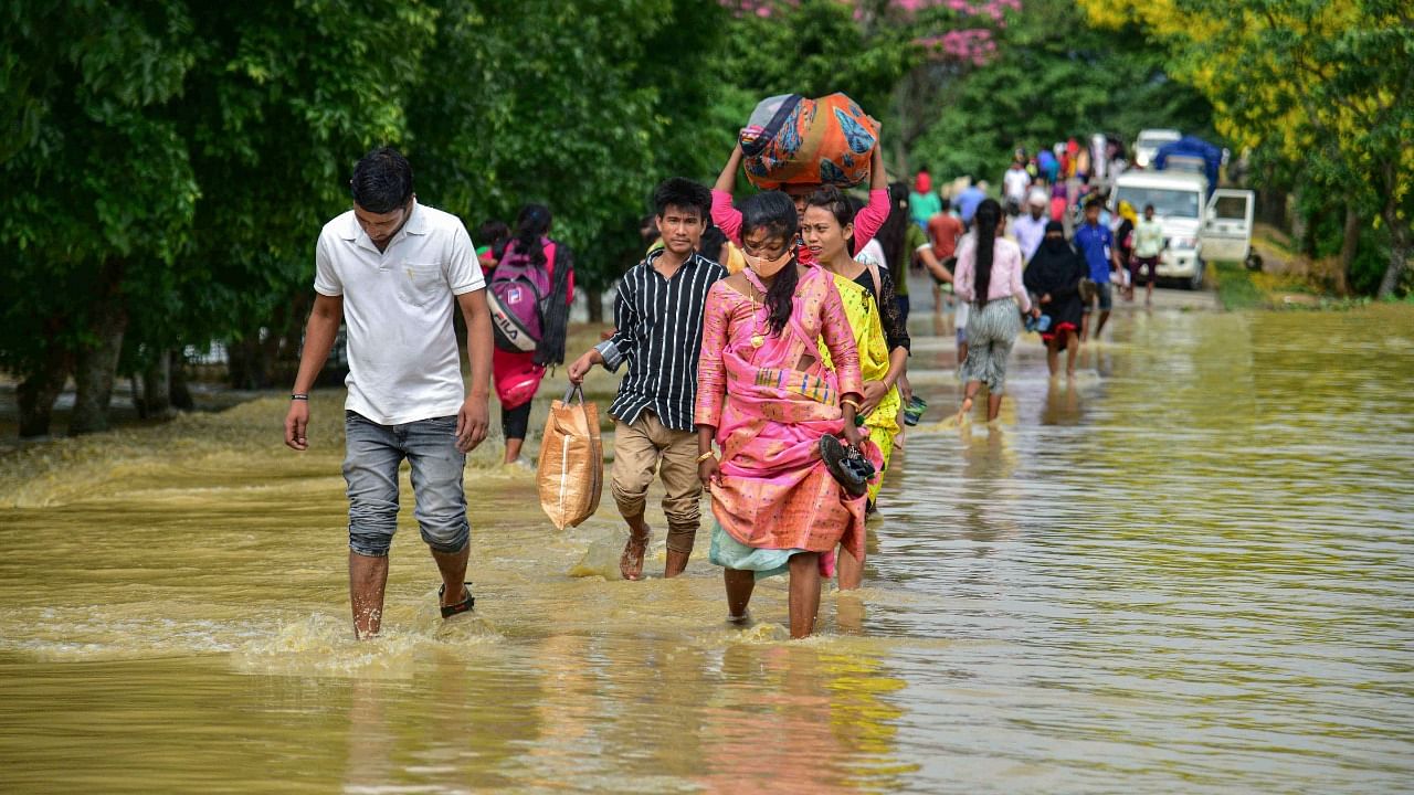 Villagers wade through a flooded road after rain at a village in Nagaon District. Credit: PTI File Photo