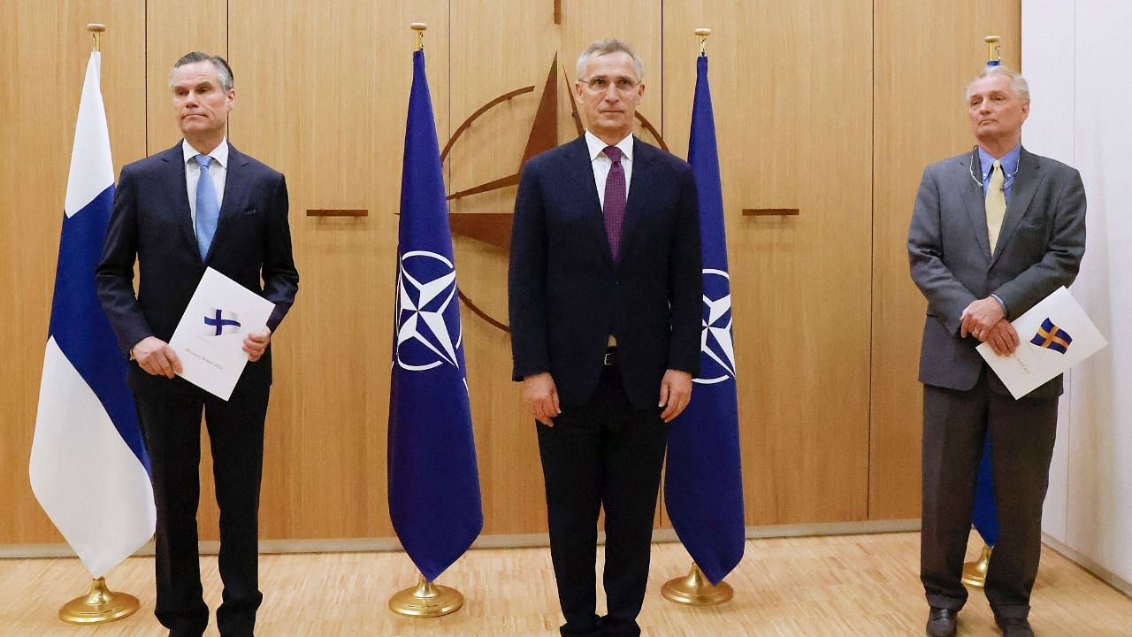 Finland's Ambassador to NATO Klaus Korhonen, NATO Secretary-General Jens Stoltenberg and Sweden's Ambassador to NATO Axel Wernhoff pose during a ceremony to mark Sweden's and Finland's application for membership in Brussels. Credit: AFP Photo