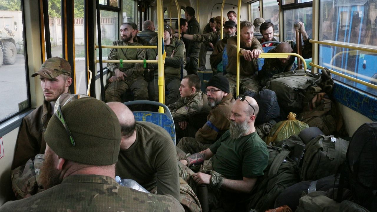 Ukrainian servicemen sit in a bus after they were evacuated from the besieged Mariupol's Azovstal steel plant. Credit: AP/PTI Photo