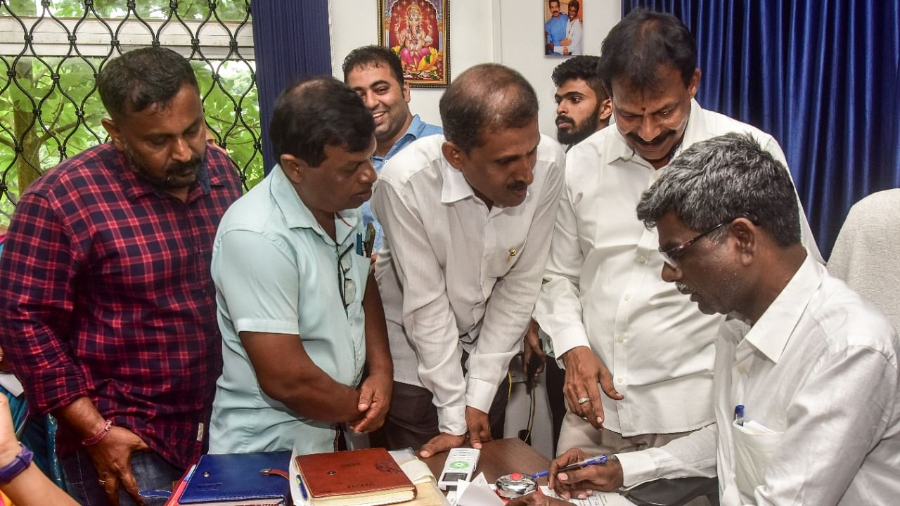 Minister for Social Welfare and Backward Classes Kota Srinivas Poojary receives petitions from the public in Mangaluru. Credit: DH Photo