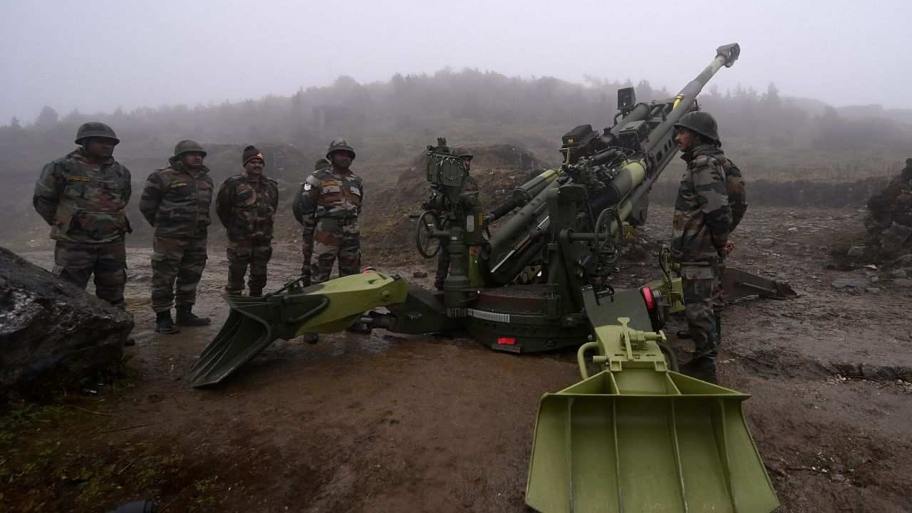 Indian Army soldiers stand next to a M777 Ultra Lightweight Howitzer positioned at Penga Teng Tso ahead of Tawang, near the Line of Actual Control (LAC), neighbouring China, in Arunachal Pradesh. Credit: AFP File Photo