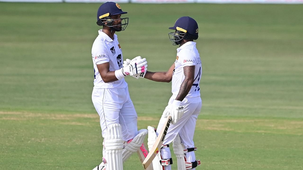 Sri Lanka's Niroshan Dickwella (R) celebrates after scoring a half-century with his teammate Dinesh Chandimal during the final day of the first Test match against Bangladesh at the Zahur Ahmed Chowdhury Stadium in Chittagong. Credit: AFP Photo