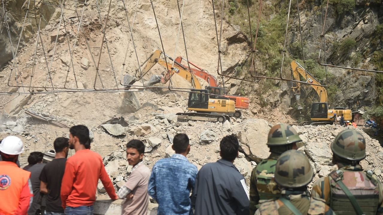 Locals gather at the site during a rescue operation after a portion of an under-construction tunnel on the Jammu-Srinagar national highway collapsed near Magarkote in Ramban district. Credit: PTI Photo