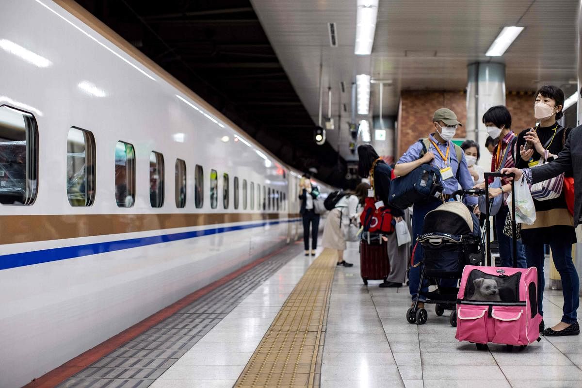 Passengers wait to board a shinkansen bullet train with their dogs for a one-hour ride to the resort town of Karuizawa at the Ueno station in Tokyo. Credit: AFP Photo