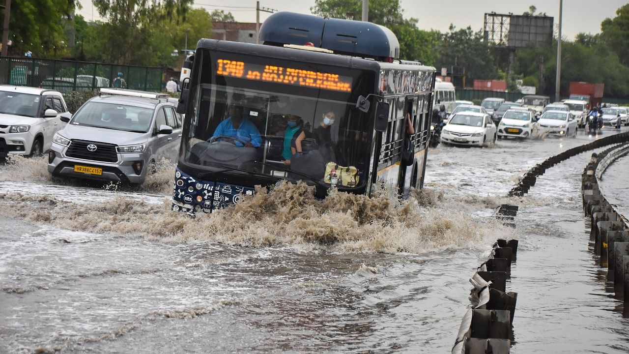 Vehicles wade through a waterlogged street after heavy rains, in Gurugram. Credit: PTI Photo