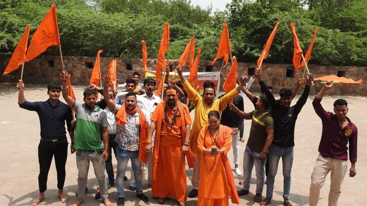 Hindu organisation Mahakal Manav Sewa members hold saffron flags protest near Qutub Minar, demand renaming of Qutub Minar as Vishnu Stambh. Credit: IANS Photo
