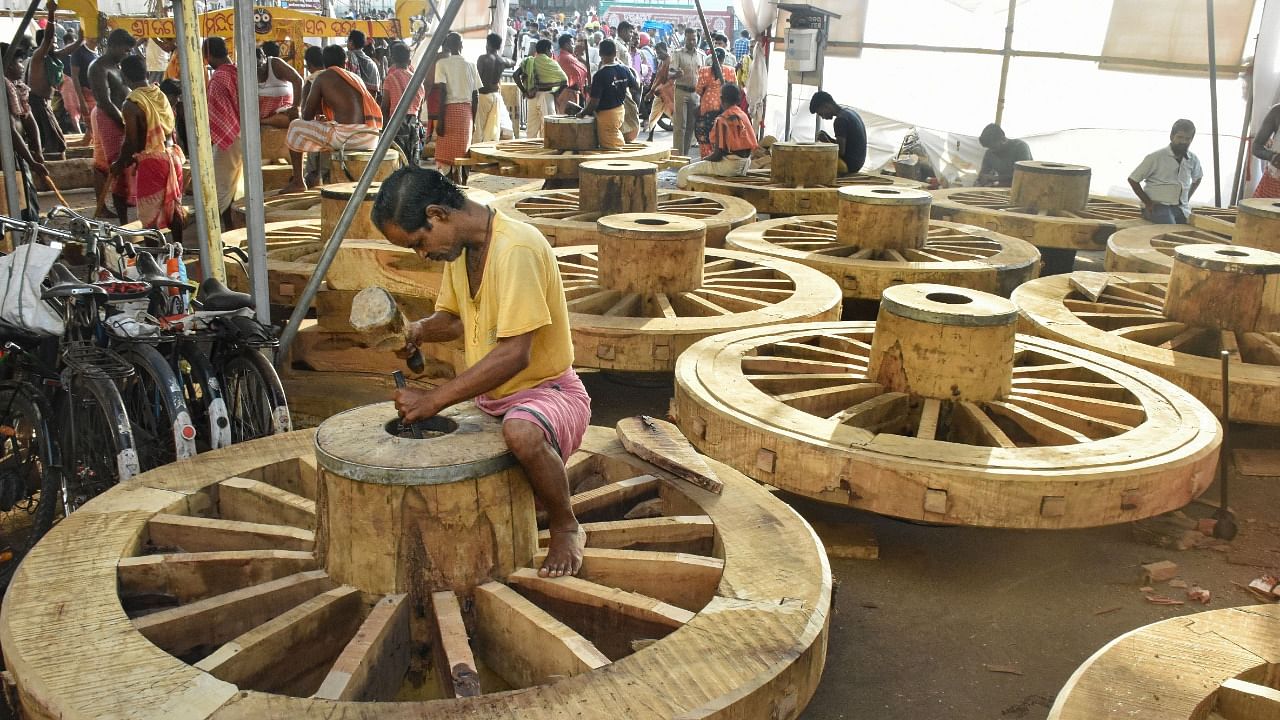 Carpenters construct wheels of chariots of Hindu deities Jagannath, Balabhadra and Subhadra ahead of the 'Rath Yatra' festival, in Puri. Credit: PTI Photo