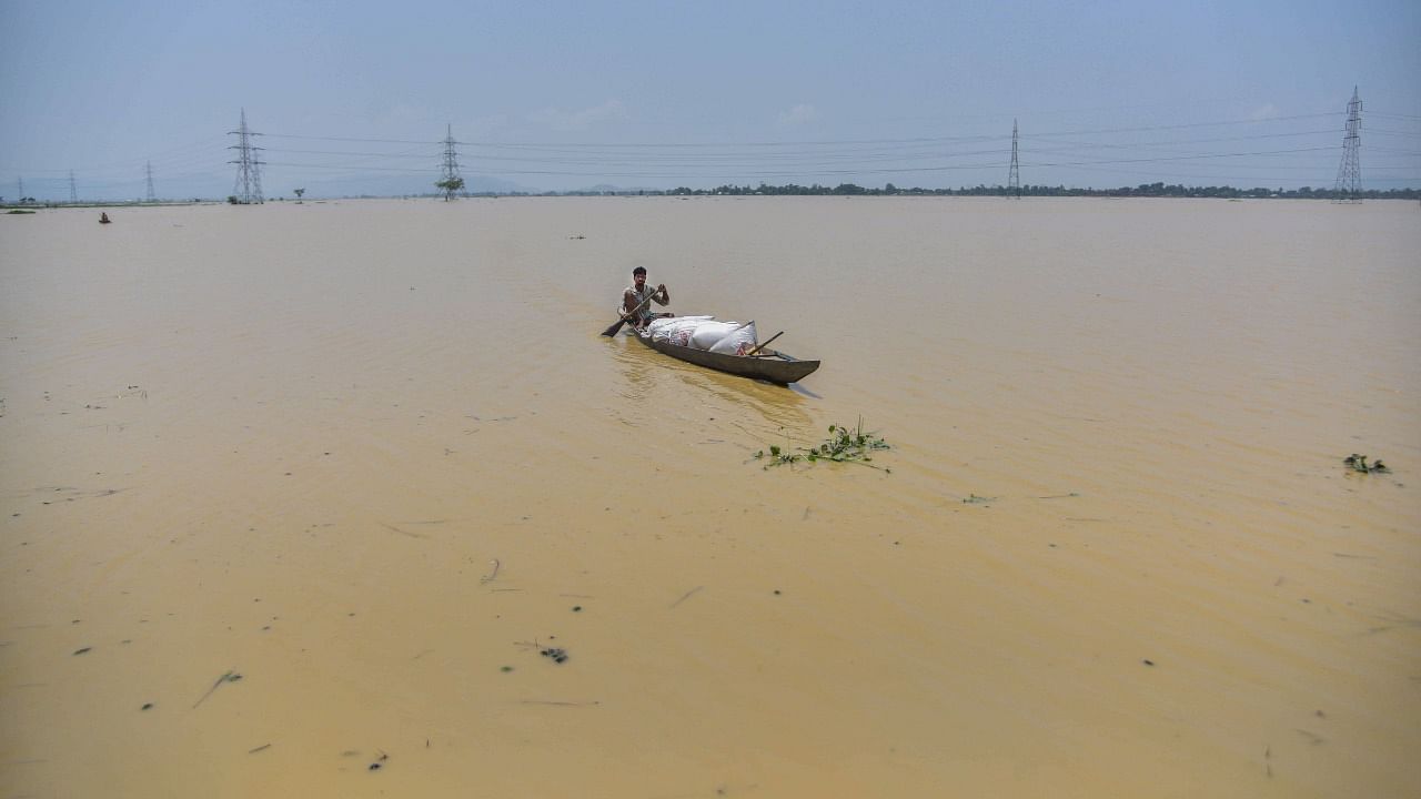 A villager uses a boat to move from a flood-affected village to a safer place after heavy rain, in Morigaon district. Credit: PTI Photo