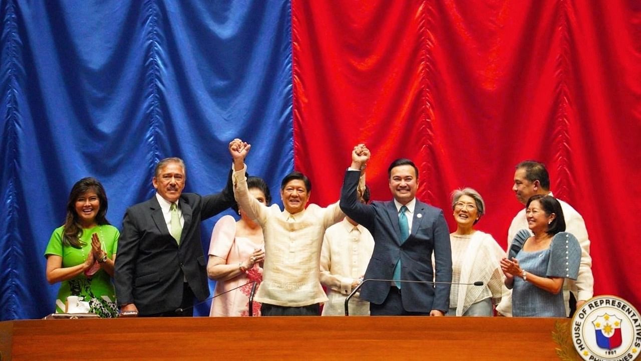 Philippine President-elect Ferdinand "Bongbong" Marcos Jr. raises hands with Senate President Vicente Sotto III and House Speaker Lord Allan Velasco during his proclamation, at the House of Representatives, in Quezon City, Metro Manila, Philippines. Credit: Reuters Photo