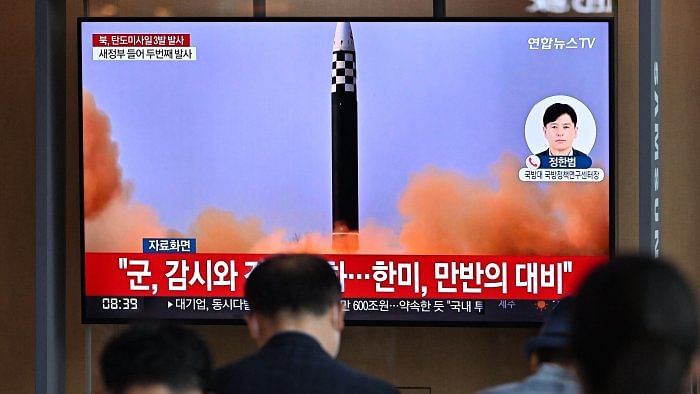 People watch a television screen showing a news broadcast with file footage of a North Korean missile test, at a railway station in Seoul . Credit: AFP Photo