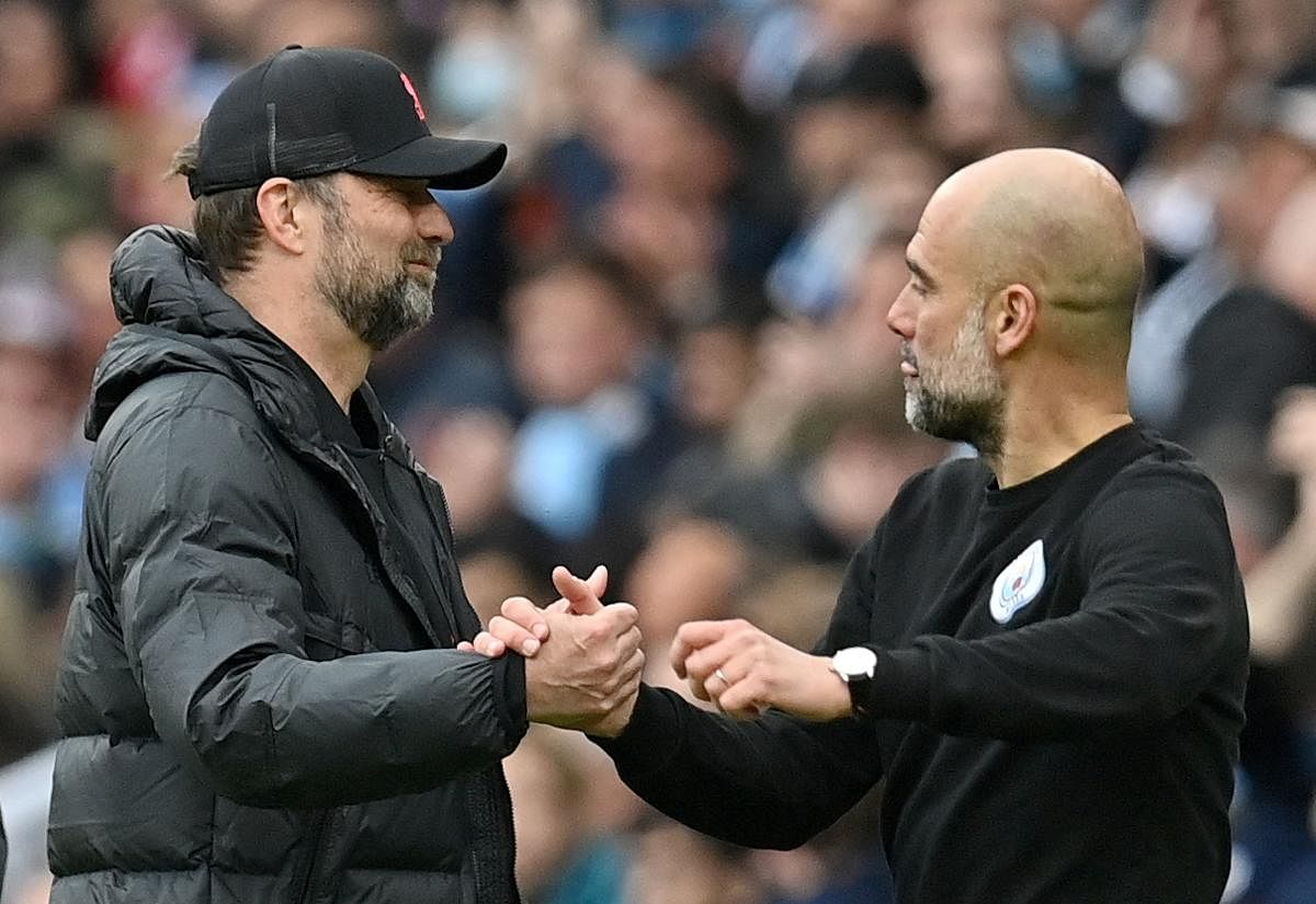 In this file photo taken on April 10, 2022 Liverpool's German manager Jurgen Klopp (L) shakes hands with Manchester City's Spanish manager Pep Guardiola. Credit: AFP Photo