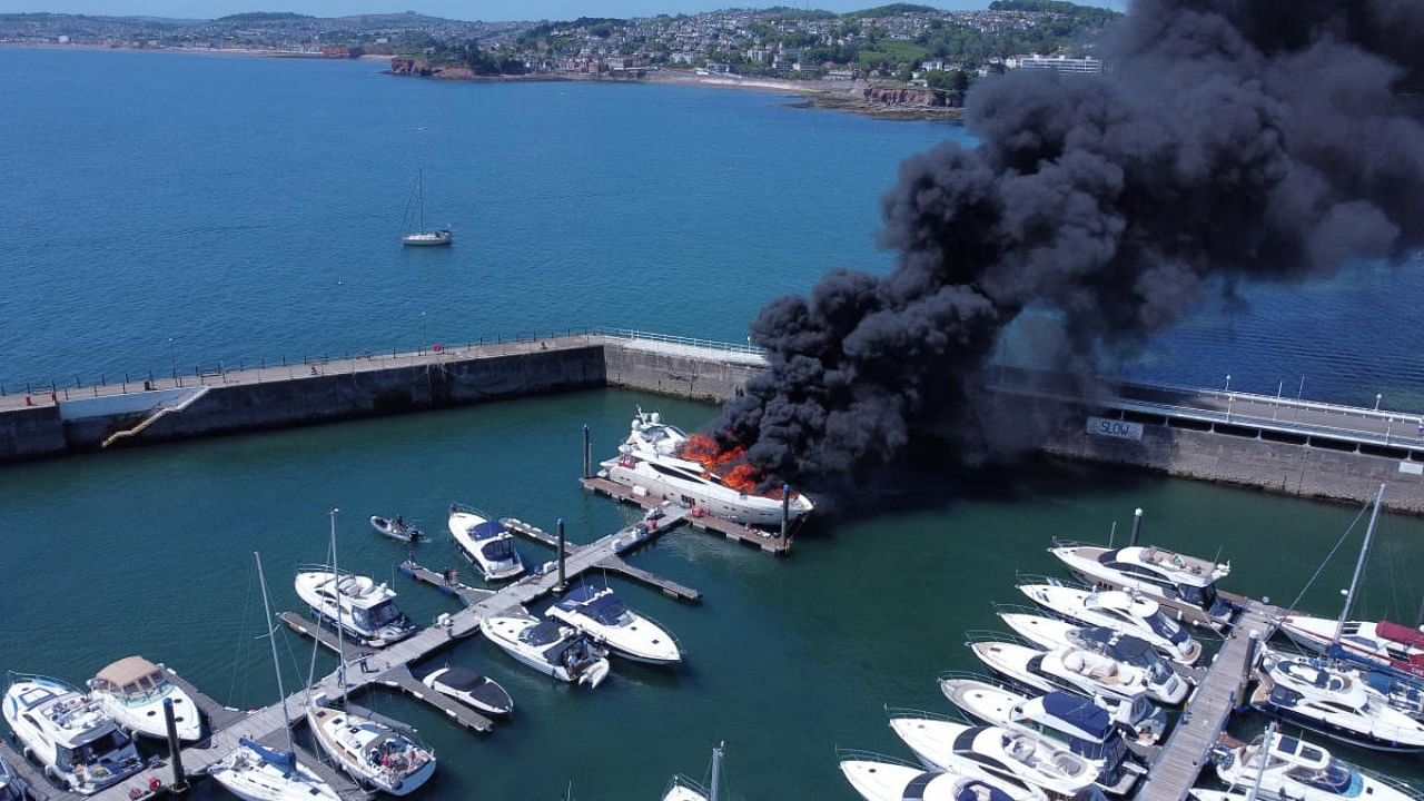 Thick black smoke rises from a fire on a yacht, at Torquay harbour in Torquay, Britain. Credit: Reuters photo/Mike Trower/Handout