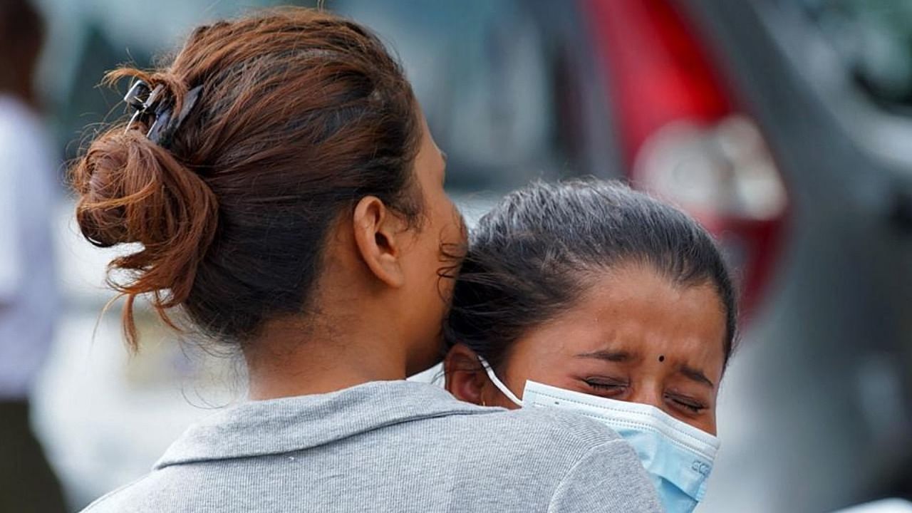 Family members and relatives of passengers on board the Twin Otter aircraft operated by Tara Air, weep outside the airport in Pokhara on May 29, 2022. Credit: AFP Photo