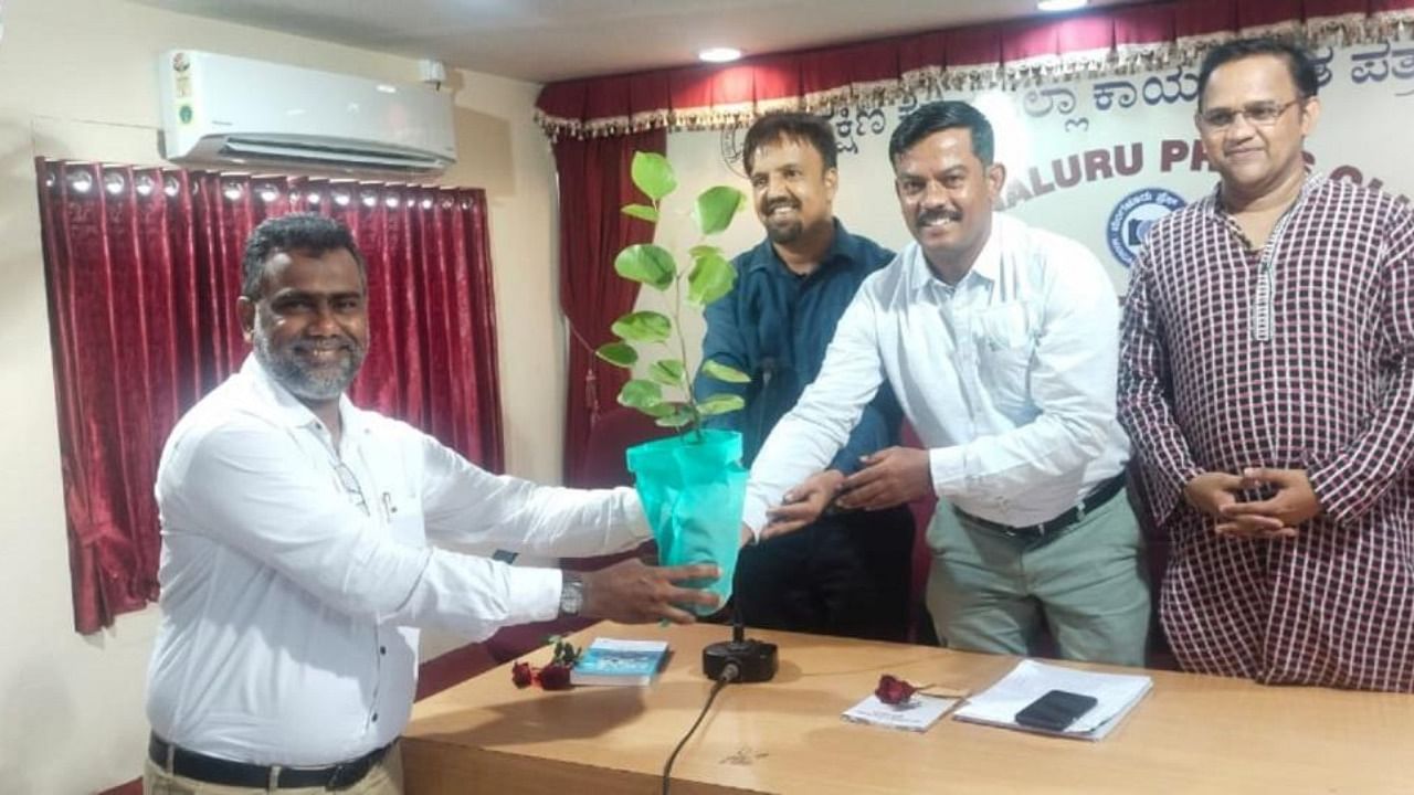 DCF Dr Y Dinesh Kumar seen distributing saplings to a journalist at Meet-The-Press programme organised by DK working Journalists Association at Patrika Bhavan in Mangaluru on Monday. Credit: DH photo