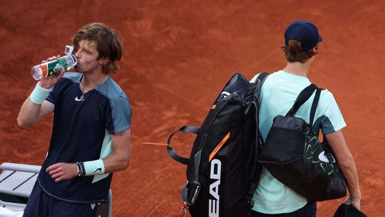 Italy's Jannik Sinner (R) leaves after his men's singles match against Russia's Andrey Rublev (L) on day nine of the Roland-Garros Open tennis tournament at the Court Suzanne-Lenglen in Paris. Credit: AFP Photo