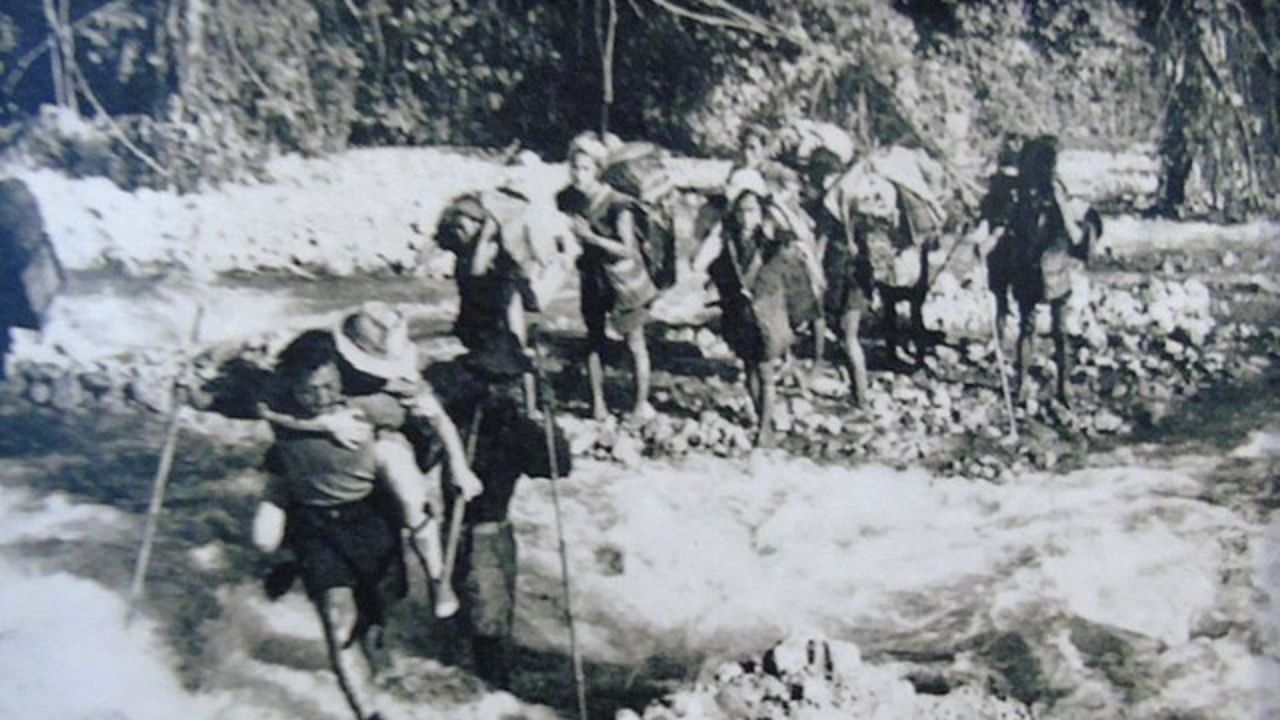 Local people helping visitors to cross the river by carrying them on their back during 1950 Assam earthquake. Credit: Wikimedia Commons