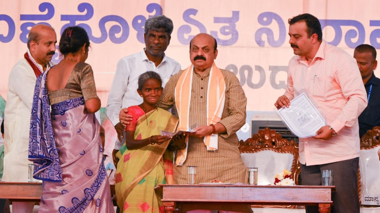 Chief Minister Basavaraj Bommai hands over title deed to a beneficiary after inaugurating Yennehole lift irrigation project at Marne near Mangaluru on Wednesday. Credit: DH photo