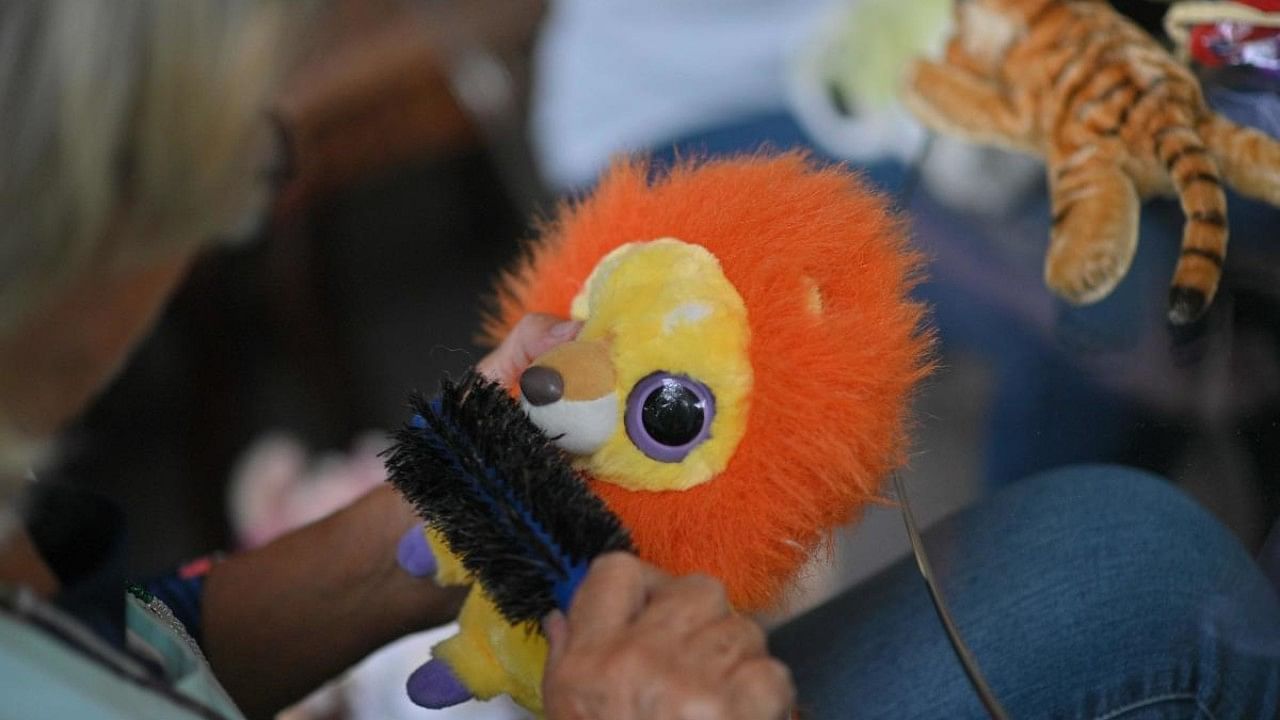 A volunteer from 'El Hospital de Peluches' (Stuffed Toy Hospital) foundation repairs a toy, in Caracas. Credit: AFP Photo