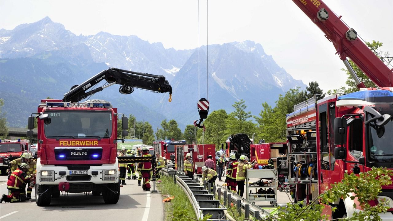 Rescue services and fire engines are seen on a motorway near the accident site of a derailed train near Burgrain, near Garmisch-Partenkirchen, southern Germany. Credit: AFP Photo