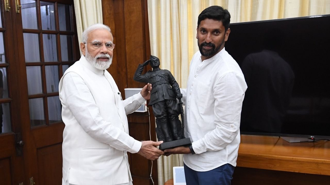 Prime Minister Narendra Modi receives a statue of Subhas Chandra Bose from sculptor Arun Yogiraj Shilpi of Mysuru. The photo was tweeted by the official handle of Modi on April 5, 2022. Credit: Special Arrangement