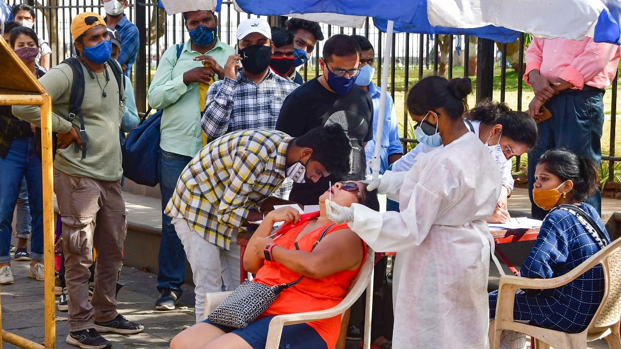 A medic conducts Covid-19 testing of a tourist at Gateway of India as others wait for their turn, amid a surge in coronavirus cases across the country, in Mumbai. Credit: PTI Photo