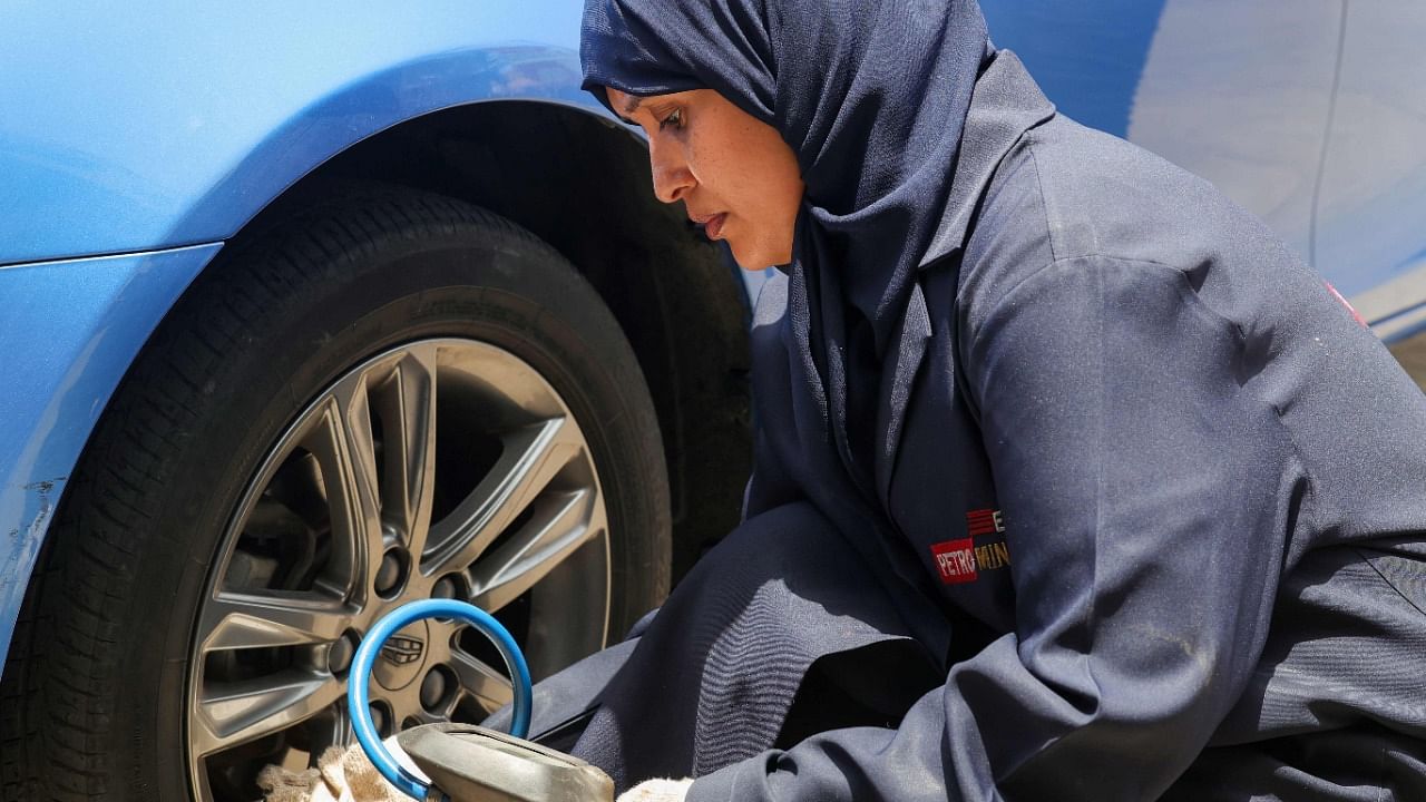 Ola Flimban working on a costumer's car at an auto quick service garage in Jeddah City. Credit: AFP Photo