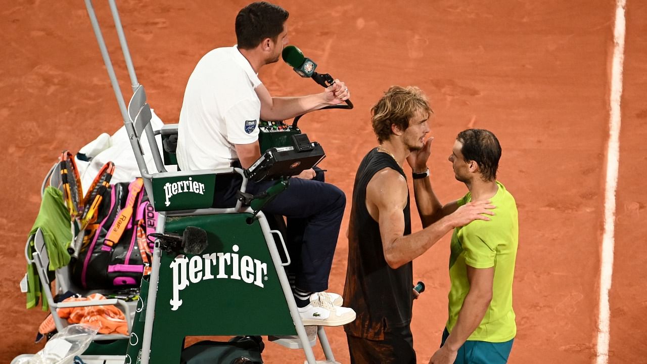 Germany's Alexander Zverev (C) is watched by umpire Renaud Lichtenstein (L) as he is comforted by Spain's Rafael Nadal (R) after being injured. Credit: AFP Photo