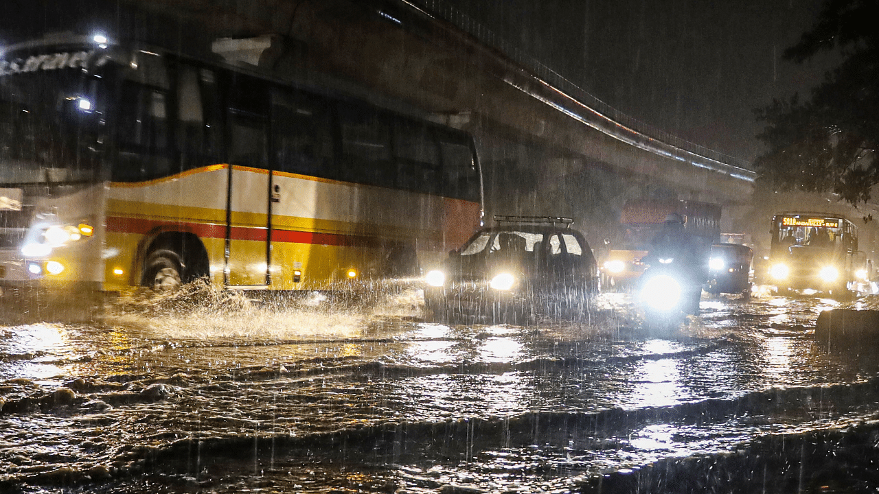 Vehicles wade through the waterlogged Mysore road during rain in Bengaluru. Credit: PTI Photo