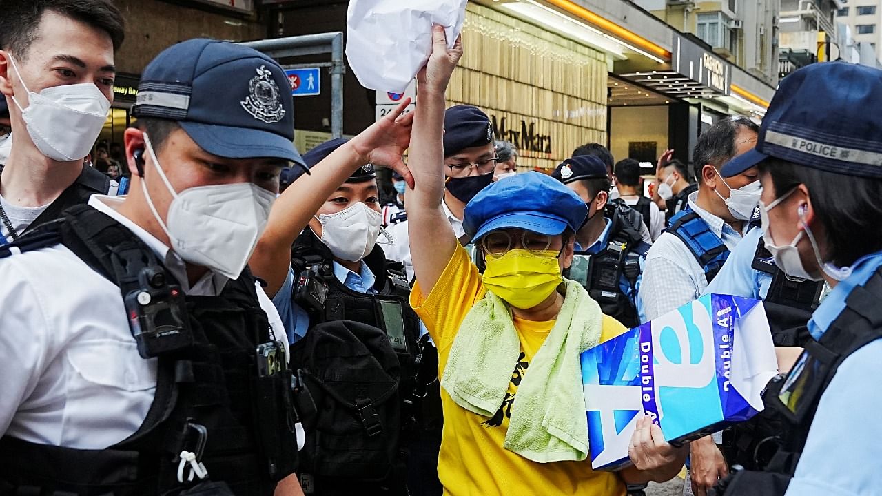 A woman holding blank papers is stopped and searched by police officers on the 33rd anniversary of the crackdown on pro-democracy demonstrations at Beijing's Tiananmen Square in 1989, in Hong Kong. Credit: Reuters photo