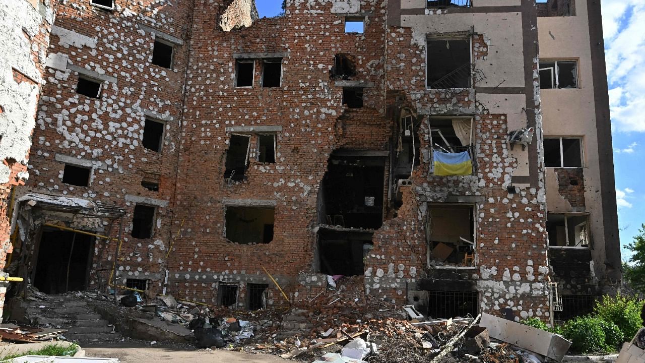 A woman walks past a destroyed residential building in the town of Irpin, north-west from Ukrainian capital of Kyiv on June 3, 2022 on the 100th day of the Russian invasion of Ukraine. Credit: AFP Photo