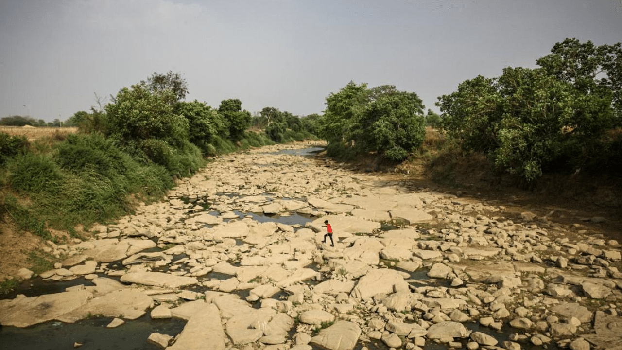  A man walks across the dried bed of the Belan river on May 20, 2022 in Mirzapur, Uttar Pradesh, India. Credit: Getty Images