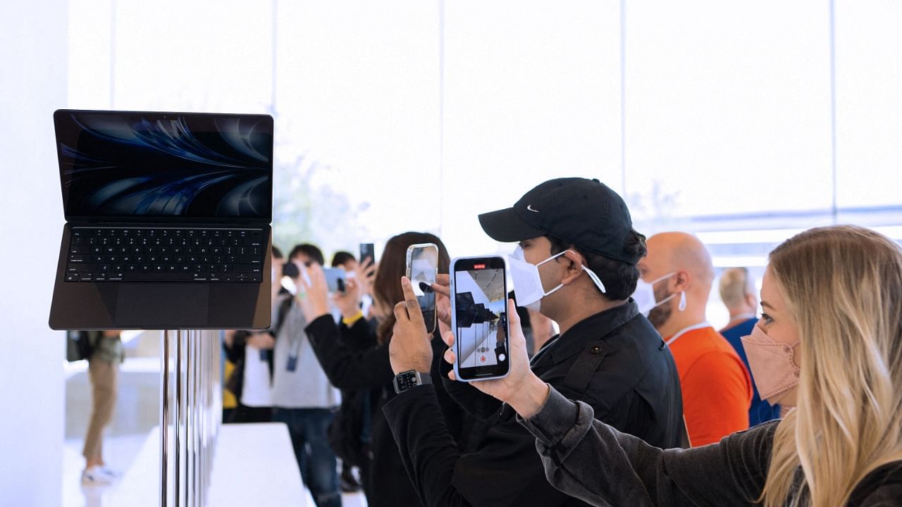 Attendees take photos of the new MacBook Airs which are displayed inside the Steve Jobs Theater during the Apple Worldwide Developers Conference (WWDC). Credit: AFP Photo