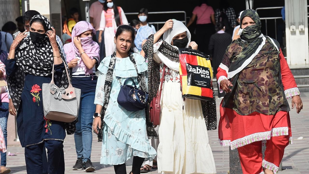 Women use scarves to shield themselves from the heat on a hot summer afternoon. Credit: PTI Photo