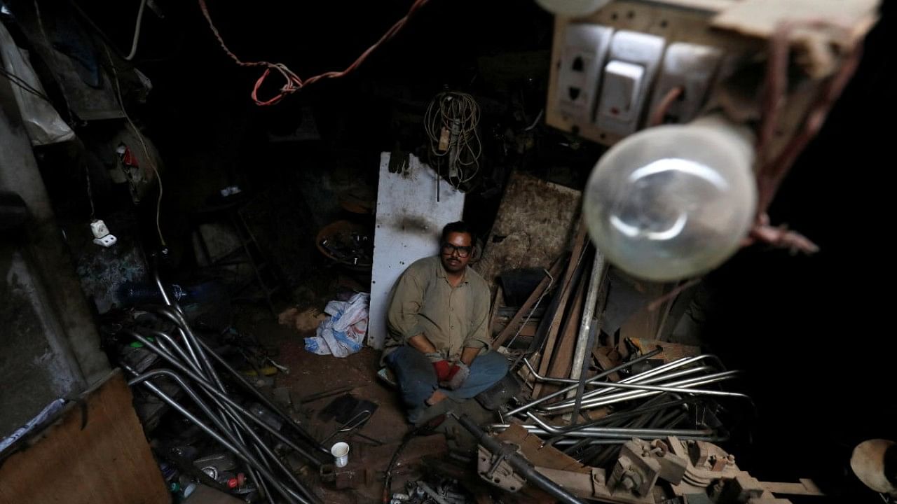 A metal-welder pauses during power outages and hot weather, at workshop in Karachi. Credit: Reuters Photo