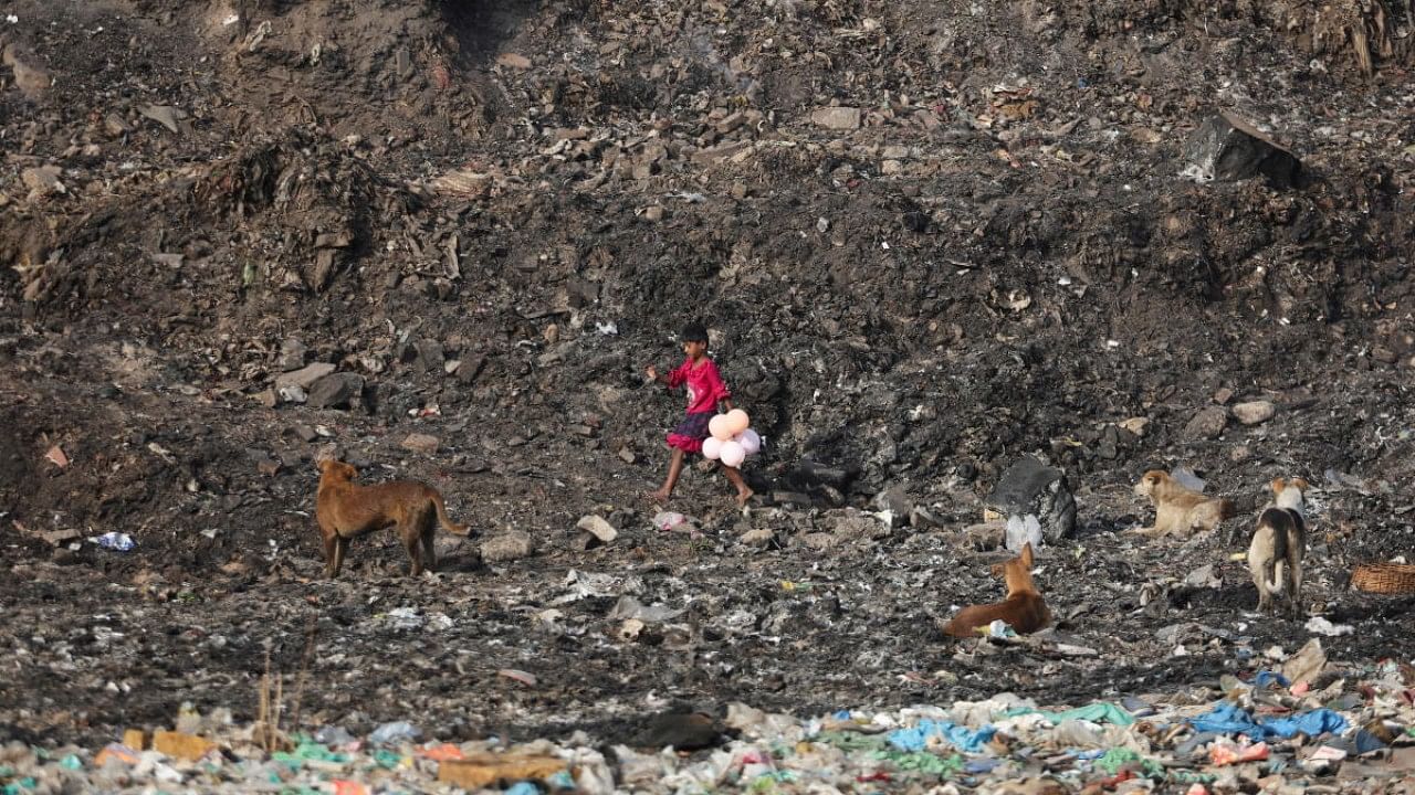 A girl carries balloons that she found at the Bhalswa landfill site. Credit: Reuters Photo