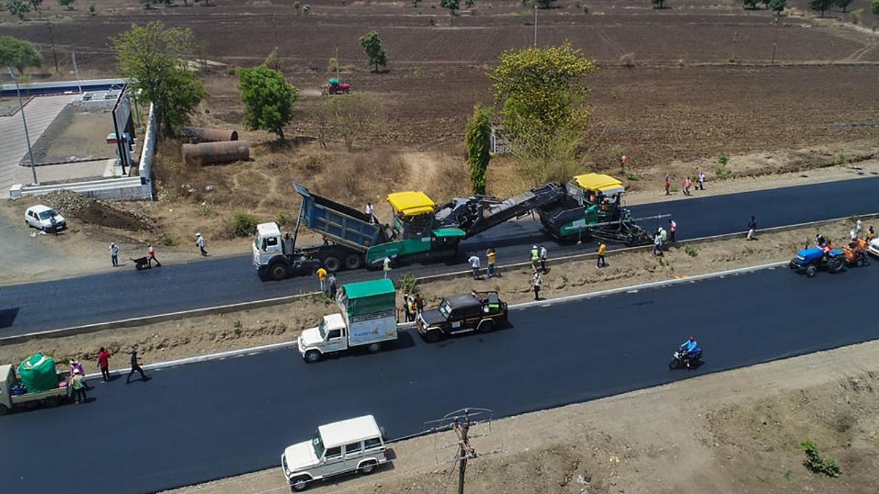 Workers construct 75 km single lane continuous Bituminous Concrete road on NH-53 between Amravati to Akola. Credit: PTI Photo