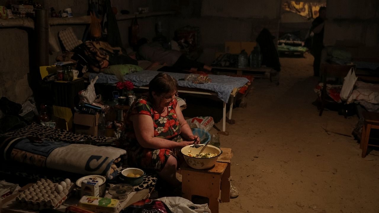 A resident prepares food in a bomb shelter, amid Russia's invasion of Ukraine, in the town of Soledar, Donetsk region Ukraine. Credit: Reuters Photo