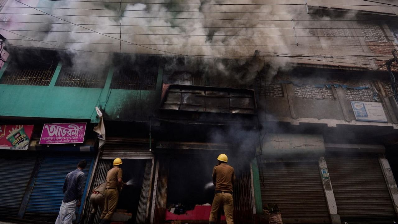 Firefighters try to douse a fire in a shop after violence erupted between police and protestors over a comment on Prophet Mohammed by BJP member Nupur Sharma, in Howrah on the outskirts of Kolkata. Credit: Reuters photo