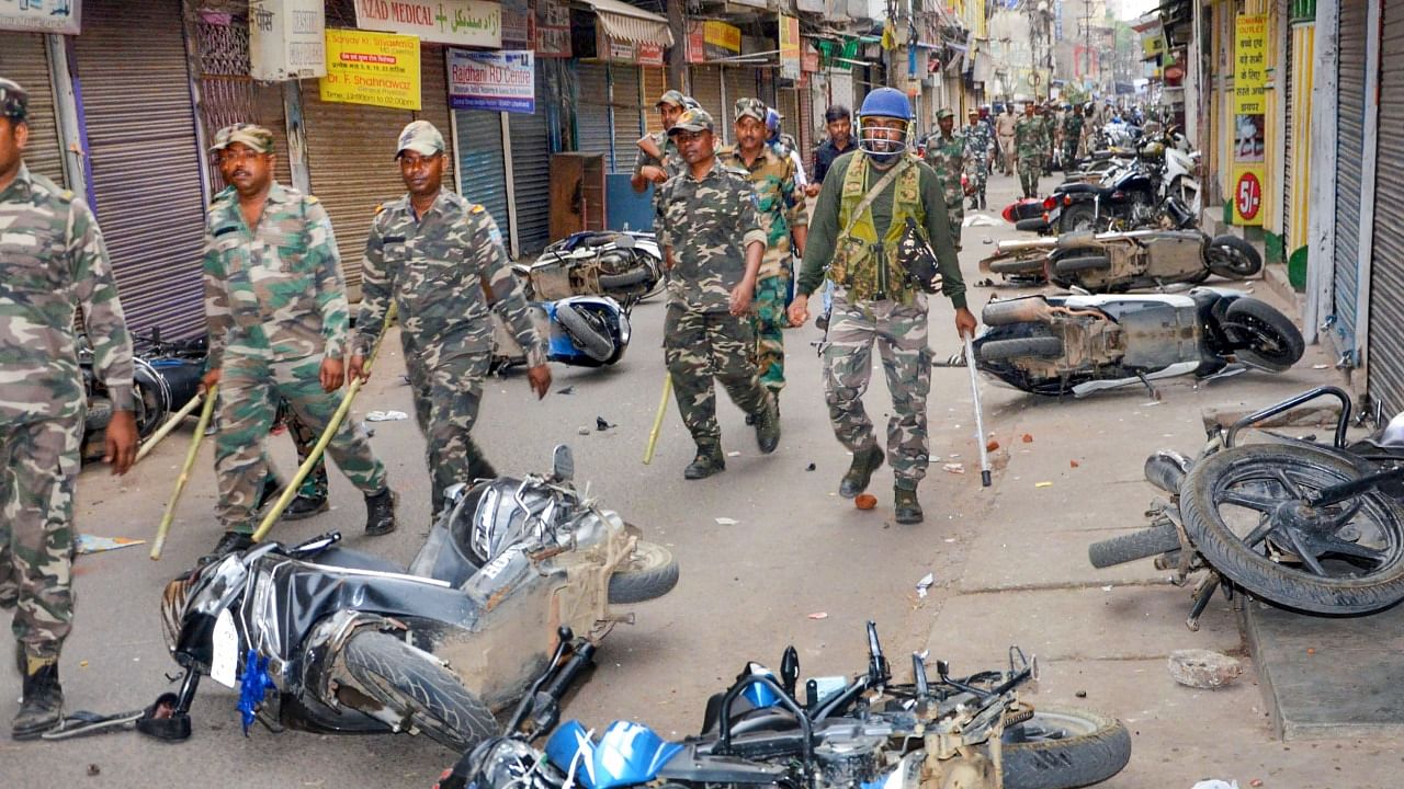 Security personnel conduct a route march as miscreants damage vehicles during a protest in Ranchi. Credit: PTI Photo